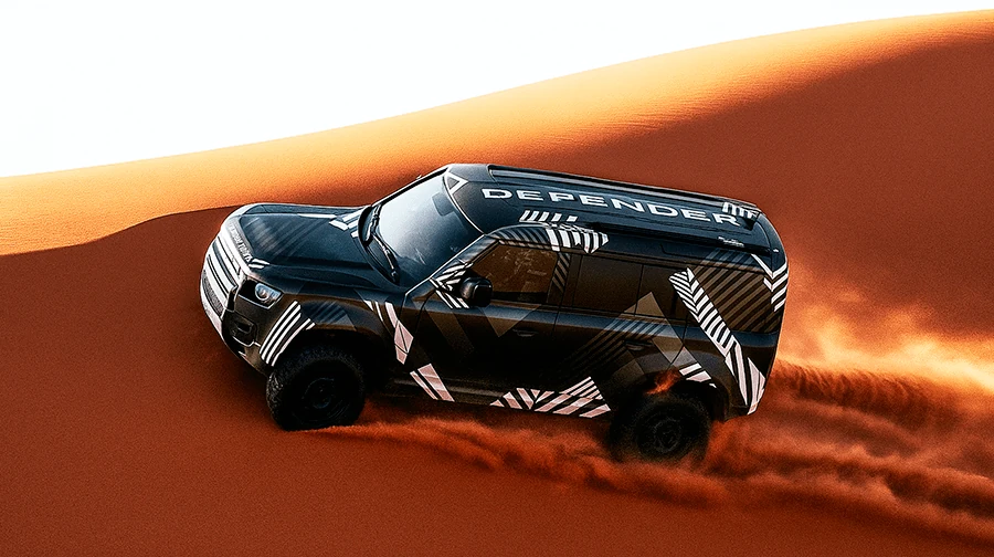 The legendary Defender conquering the endless desert sands, showcasing its power and reliability in extreme conditions.
